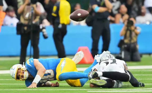 Los Angeles Chargers quarterback Justin Herbert (10) fumbles as he is tackled by Las Vegas Raiders defensive end Malcolm Koonce (51) during the second half of an NFL football game in Inglewood, Calif., Sunday, Sept. 20, 2026. (AP Photo/Jayne Kamin-Oncea)