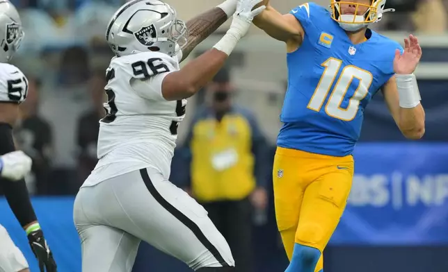 Los Angeles Chargers quarterback Justin Herbert (10) throws under pressure from Las Vegas Raiders defensive tackle Jonah Laulu (96) during the second half of an NFL football game in Inglewood, Calif., Sunday, Sept. 20, 2026. (AP Photo/Jayne Kamin-Oncea)