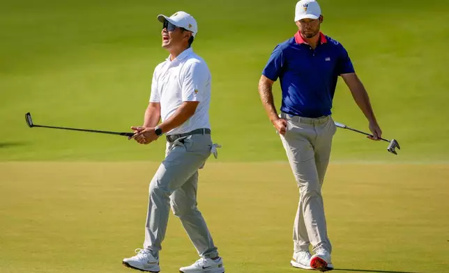 International teams' Ryo Hisatsune, of Japan, reacts to missed shot on the eighth green as USA teams' Sam Burns looks on during a Presidents Cup golf tournament third round four-ball match at Medinah Country Club, Saturday, Sept. 26, 2026, in Medinah, Ill. (AP Photo/Chris Carlson)