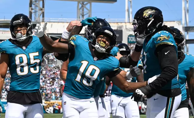 Jacksonville Jaguars wide receiver Josh Cameron (19) celebrates with teammates after scoring a touchdown against the New England Patriots in the first half during an NFL football game in Jacksonville, Fla., Sunday, Sept. 27, 2026. (AP Photo/Phelan M. Ebenhack)