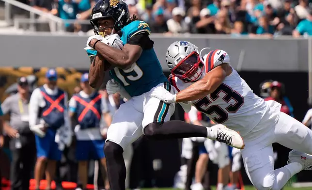 Jacksonville Jaguars wide receiver Josh Cameron (19) scores a touchdown against New England Patriots linebacker Christian Elliss (53) in the first half during an NFL football game in Jacksonville, Fla., Sunday, Sept. 27, 2026. (AP Photo/Mike Stewart)