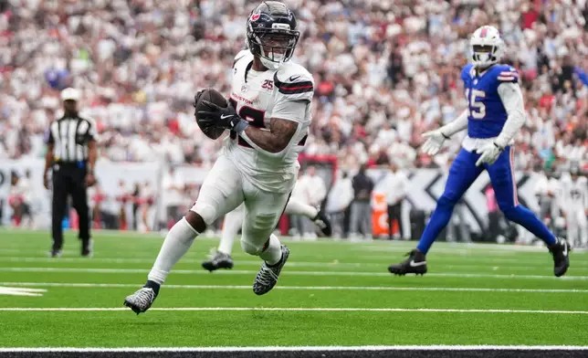 Houston Texans running back David Montgomery, left, runs the ball into the end zone for a touchdown during the second half of an NFL football game against the Buffalo Bills, Sunday, Sept. 13, 2026, in Houston. (AP Photo/Eric Christian Smith)
