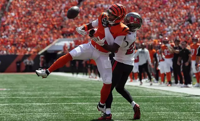Cincinnati Bengals wide receiver Ja'marr Chase (1) can't hang onto a pass as he is defended by Tampa Bay Buccaneers cornerback Jacob Parrish (25) in the first half of an NFL football game Sunday, Sept. 13, 2026, in Cincinnati. (AP Photo/Joshua A. Bickel)