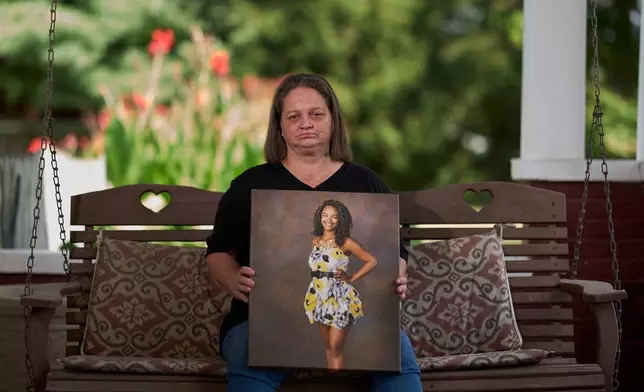 Christy Spivey poses with a portrait of her late daughter, Tasia Fortune, on Tuesday, Sept. 8, 2026, in Marion, Ky. (AP Photo/George Walker IV)