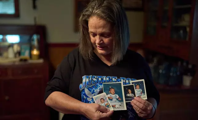 Christy Spivey hold baby pictures of her late daughter, Tasia Fortune, on Tuesday, Sept. 8, 2026, in Marion, Ky. (AP Photo/George Walker IV)