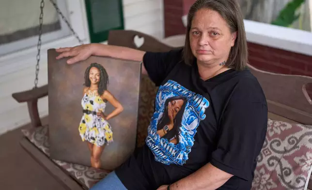 Christy Spivey poses with a portrait of her late daughter, Tasia Fortune, on Tuesday, Sept. 8, 2026, in Marion, Ky. (AP Photo/George Walker IV)