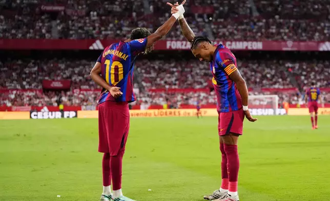 Barcelona's Raphinha, right, celebrates with Lamine Yamal after scoring his side's second goal the Spanish La Liga soccer match between Sevilla and Barcelona in Seville, Spain, Saturday, Sept. 19, 2026. (AP Photo/Jose Breton)