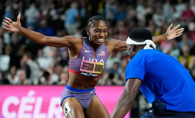Melissa Jefferson-Wooden, of the United States, celebrates with sprinter Kenneth Bednarek, also of the United States, after winning the women's 200 meters final at the World Athletics Ultimate Championship in Budapest, Hungary, Sunday, Sept. 13, 2026. (AP Photo/Matthias Schrader)
