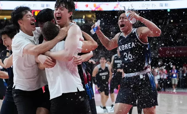 South Korean players and support staff celebrate after winning the men's basketball final against Japan at the Asian Games in Nagoya, Japan, Sunday, Sept. 20, 2026. (AP Photo/Aaron Favila)