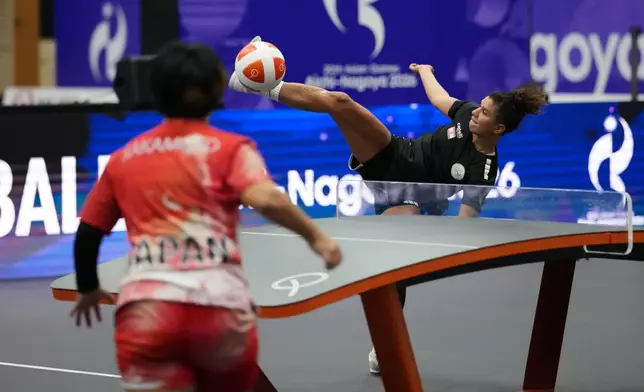 Lebanon's Dandal Kamar, right, kicks the ball against Japan's Yuina Sakamoto during their Teqball quarterfinals match in Nagoya, Japan, Friday, Sept. 18, 2026. (AP Photo/Aaron Favila)