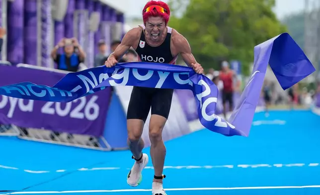 Takumi Hojo of Japan reacts as he wins during the men's individual triathlon at the Asian Games in Gamagori, Japan, Sunday Sept. 20, 2026. (AP Photo/Dita Alangkara)