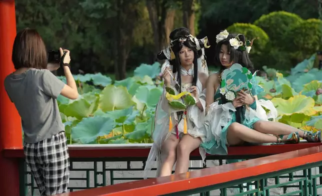 Young women wearing cosplay costumes pose for photos at a park in Beijing, Saturday, Sept. 12, 2026. (AP Photo/Achmad Ibrahim)