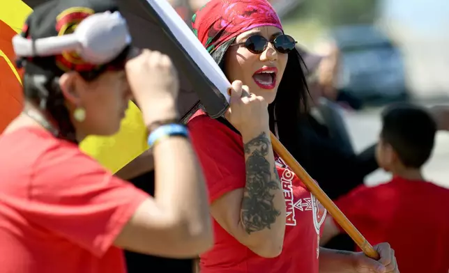 Danelle Kawasaki, a spokeswoman for the Montana American Indian Movement, protests near the Foundations for Nations church in Arapahoe, Wyo., on Sunday, Aug. 16, 2026. (AP Photo/Thomas Peipert)