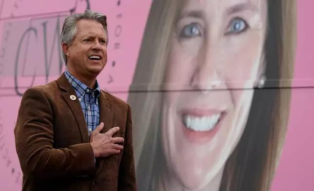 FILE - Rep. Roger Marshall, R-Kan., stands for the national anthem in front of photo of Supreme Court nominee Amy Coney Barrett while attending a Concerned Women for America event outside a gun store in Kansas City, Kan. Wednesday, Oct. 21, 2020. (AP Photo/Charlie Riedel, File)