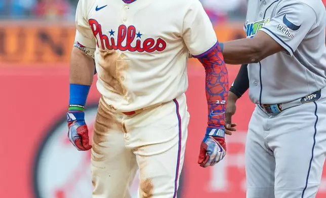 Philadelphia Phillies designated hitter Kyle Schwarber, left, reacts after hitting an RBI double while Tampa Bay Rays second baseman Richie Palacios, right, looks on during the second inning of a baseball game, Sunday, Sept. 27, 2026, in Philadelphia. (AP Photo/Laurence Kesterson)