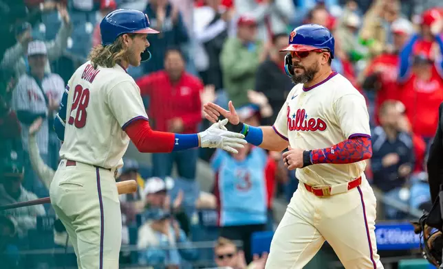 Philadelphia Phillies designated hitter Kyle Schwarber, right, is cheered by Alec Bohm, left, after scoring on an RBI double by Bryson Stott during the first inning of a baseball game against the Tampa Bay Rays, Sunday, Sept. 27, 2026, in Philadelphia. (AP Photo/Laurence Kesterson)