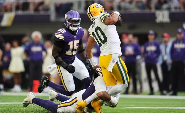 Green Bay Packers quarterback Jordan Love (10) is sacked by Minnesota Vikings defensive tackle Levi Drake Rodriguez, bottom, as Dallas Turner (15) looks on during the second half of an NFL football game, Sunday, Sept. 13, 2026, in Minneapolis, Minn. (AP Photo/Abbie Parr)
