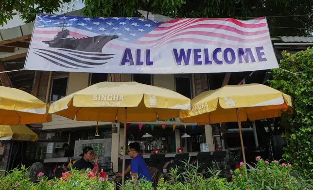 Customers of a restaurant sit under a banner in Pattaya, Thailand, on Sept. 1, 2026. (AP Photo/Sakchai Lalit)