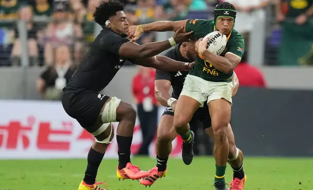 South Africa's Kurt-Lee Arendse, right, attempts to break the tackle of New Zealand's Peter Lakai during their rugby international in Baltimore, USA, Saturday, Sept. 12, 2026. (AP Photo/Stephanie Scarbrough)