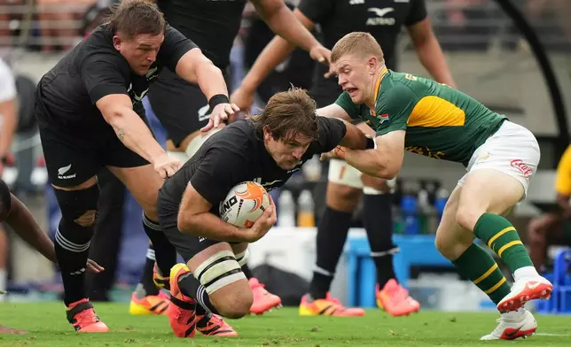 New Zealand's Ethan Blackadder runs at South Africa's Morne van den Berg, right, as teammate Ethan De Groot, follows during their rugby international in Baltimore, USA, Saturday, Sept. 12, 2026. (AP Photo/Stephanie Scarbrough)