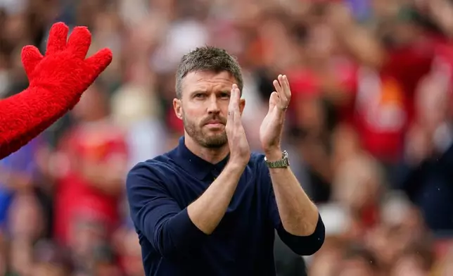 Manchester United's head coach Michael Carrick applauds ahead of the English Premier League soccer match between Manchester United and Ipswich Town in Manchester, England, Sunday, Aug. 30, 2026. (AP Photo/Dave Thompson)