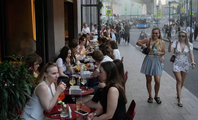 FILE - People sit at a sidewalk cafe on a hot summer day in Moscow, Friday, July 3, 2026. (AP Photo/Pavel Bednyakov, File)