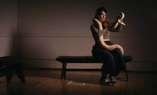 Performance artist Zoe Ziegfeld who plays the part of a snake charmer poses for a portrait with a snake during auditions to select a snake for a part in an adaptation of Mozart’s “Così fan tutte," at the Metropolitan Opera in New York, Friday, Aug. 28, 2026. (AP Photo/Andres Kudacki)