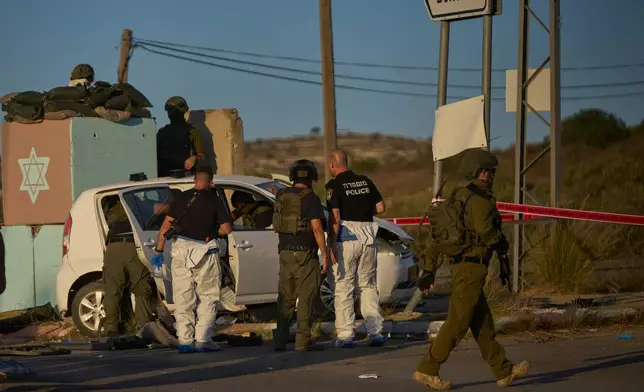 Israeli security forces inspect the scene where, according to police, a Palestinian man was shot and killed after ramming his car into a security checkpoint and seriously wounding an officer, near the West Bank Jewish settlement of Beit Horon, Wednesday, Sept. 23, 2026.(AP Photo/Ohad Zwigenberg)