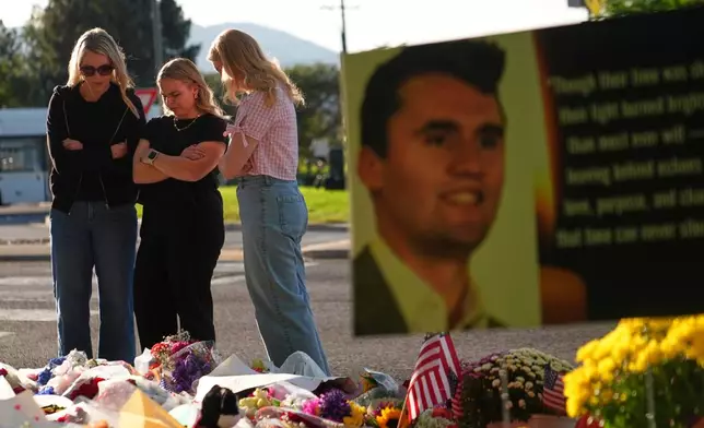 FILE - Women pray at a memorial outside Utah Valley University after Turning Point USA CEO and co-founder Charlie Kirk was shot and killed, Sept. 13, 2025, in Orem, Utah. (AP Photo/Lindsey Wasson, File)