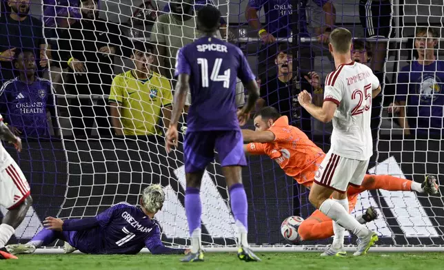 Orlando City forward Antoine Griezmann (7) scores a goal past Toronto FC goalkeeper Luka Gavran, second from right, during the first half of an MLS soccer match, Saturday, Sept. 12, 2026, in Orlando, Fla. (AP Photo/Phelan M. Ebenhack)