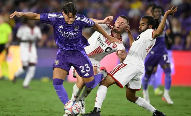 Orlando City forward Harvey Sarajian (23) competes for the ball against Toronto FC defender Walker Zimmerman, center, and defender Raheem Edwards, right, during the second half of an MLS soccer match, Saturday, Sept. 12, 2026, in Orlando, Fla. (AP Photo/Phelan M. Ebenhack)