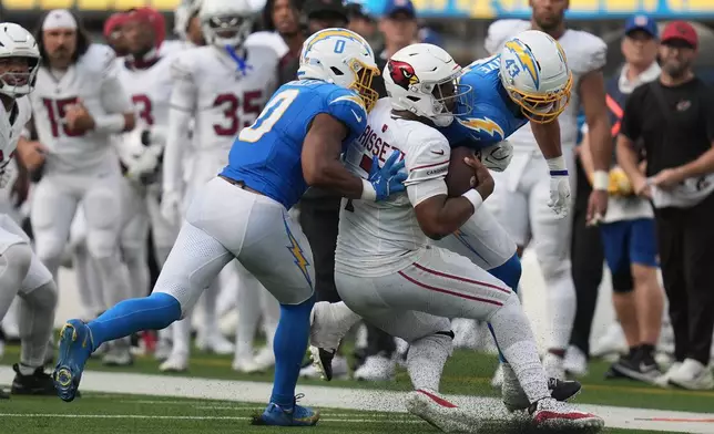 Arizona Cardinals quarterback Jacoby Brissett, middle, is hit by Los Angeles Chargers linebacker Daiyan Henley (0) and linebacker Troy Dye (43) during the second half of an NFL football game, Sunday, Sept. 13, 2026, in Inglewood, Calif. (AP Photo/Gregory Bull)