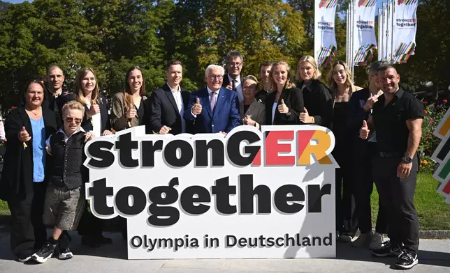Germany's President Frank-Walter Steinmeier, center, with politicians and athletes pose for the media at the extraordinary DOSB General Assembly to select Germany's Olympic bid for 2036, 2040, or 2044, in Baden-Baden, Germany, Saturday Sept. 26, 2026. (Marijan Murat/dpa via AP)