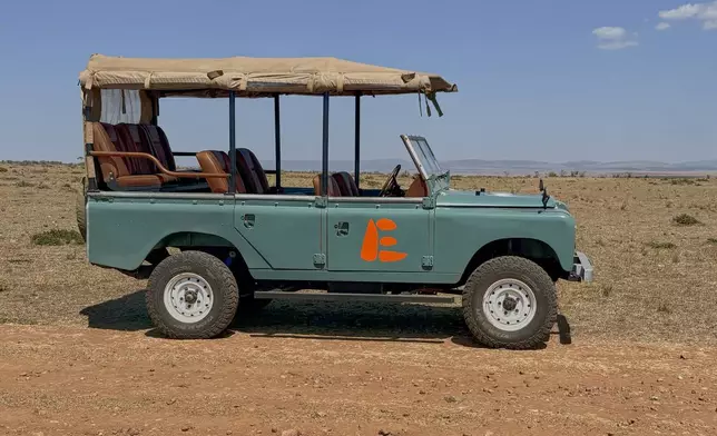 In this photo taken with a smartphone, an electric safari van operated by Emboo Camp is parked in the Maasai Mara, Kenya, Saturday, Aug. 29, 2026. (AP Photo/Allan Olingo)