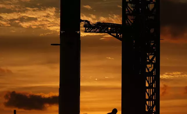A man watches at sunset as SpaceX's mega rocket Starship is prepared for a test flight from Starbase, Texas, Sunday, Sept. 27, 2026. (AP Photo/Eric Gay)