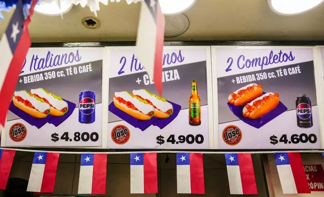 Chilean flags decorate a menu board offering combo deals for "completos," traditional Chilean hot dogs topped with mashed avocado, diced tomatoes and mayonnaise, in downtown Santiago, Chile, Thursday, Sept. 10, 2026. (AP Photo/Esteban Félix)