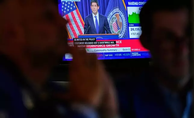 Screens display a news conference held by Federal Reserve chairman Kevin Warsh on the floor of the New York Stock Exchange in New York, Wednesday, Sept. 16, 2026. (AP Photo/Seth Wenig)