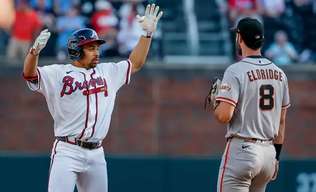 Atlanta Braves designated hitter Drake Baldwin, left, reacts after hitting a double as San Francisco Giants first baseman Bryce Eldridge (8) looks on during the first inning of a baseball game, Monday, Aug. 31, 2026, in Atlanta. (AP Photo/Erik S. Lesser)