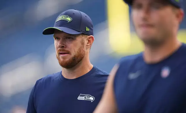 Seattle Seahawks quarterback Sam Darnold, left, walks the field during warmups before an NFL football game against the New England Patriots, Wednesday, Sept. 9, 2026, in Seattle. (AP Photo/Lindsey Wasson)