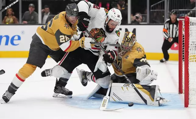 Chicago Blackhawks' Jordan Greenway (12) falls into Vegas Golden Knights goaltender Carter Hart (79) during the first period of an NHL hockey game Tuesday, Sept. 29, 2026, in Las Vegas. (AP Photo/John Locher)