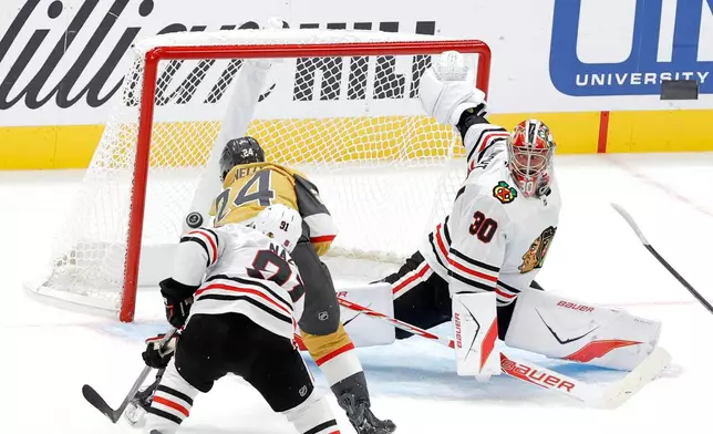 Vegas Golden Knights left wing Trevor Connelly (24) scores between Chicago Blackhawks center Frank Nazar (91) and goaltender Spencer Knight (30) during the first period of an NHL hockey game Tuesday, Sept. 29, 2026, in Las Vegas. (Steve Marcus/Las Vegas Sun via AP)