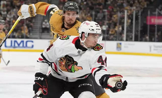 Chicago Blackhawks defenseman Wyatt Kaiser (44) knocks the puck out of the air against Vegas Golden Knights center Brett Howden (21) during the second period of an NHL hockey game Tuesday, Sept. 29, 2026, in Las Vegas. (AP Photo/John Locher)