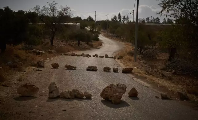 Rocks placed by Palestinians block a road in an effort to prevent Israeli settlers from entering this area of the West Bank village of Burqa, east Ramallah, Friday, Sept. 18, 2026. (AP Photo/Leo Correa)