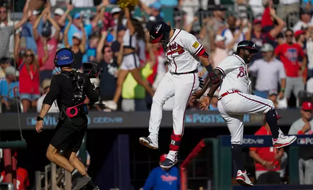 Atlanta Braves' Austin Riley celebrates with Tommy Watkins after Riley hit a three-run home run in the eighth inning against the Philadelphia Phillies during Game 1 of baseball's National League Wild Card Series, Tuesday, Sept. 29, 2026, in Atlanta. (AP Photo/Brynn Anderson)