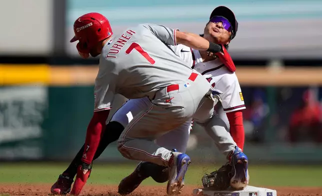 Philadelphia Phillies' Trea Turner (7) hits Atlanta Braves shortstop Ha-Seong Kim (7) while being tagged out attempting to steal second base in the third inning during Game 1 of baseball's National League Wild Card Series Tuesday, Sept. 29, 2026, in Atlanta. (AP Photo/Brynn Anderson)