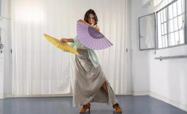 Carmen Torres, a professional flamenco dancer, rehearses a guajira, a flamenco style that traditionally incorporates the use of a fan, in Seville, Spain, on Aug. 27, 2026. (AP Photo/Laura Leon)