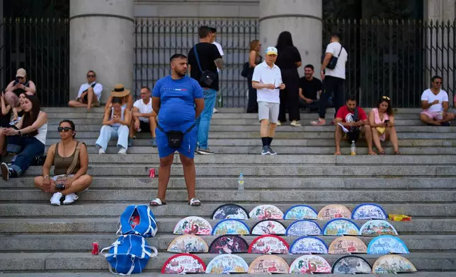 A street vendor sells fans near the Royal Palace in Madrid, Spain, on Aug. 20, 2026. (AP Photo/Manu Fernandez)