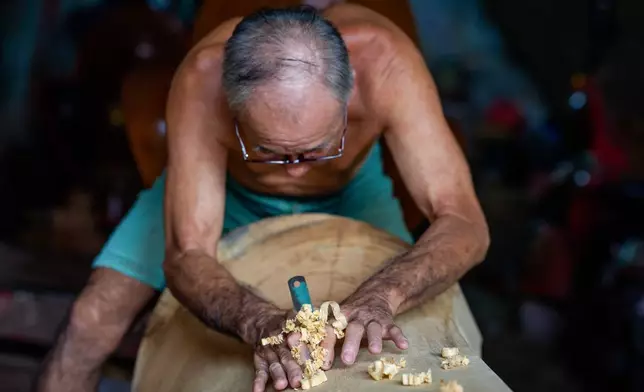 Goh Khuay Par works on a Mei Hua coffin at his family's workshop in Muar, Malaysia, Thursday, Sept. 3, 2026. (AP Photo/Vincent Thian)