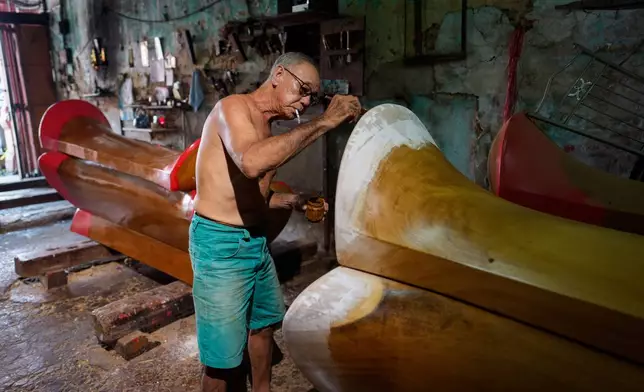 Goh Khuay Par applies a coat of finish to a Mei Hua coffin at his family's workshop in Muar, Malaysia, Monday, Sept. 7, 2026. (AP Photo/Vincent Thian)