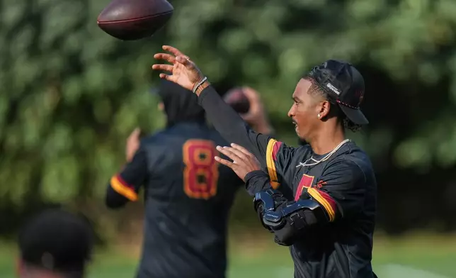 Washington Commanders quarterback Jayden Daniels (5), throws a pass during a NFL Football practice session in London, Wednesday, Sept. 30, 2026. (AP Photo/Alastair Grant)
